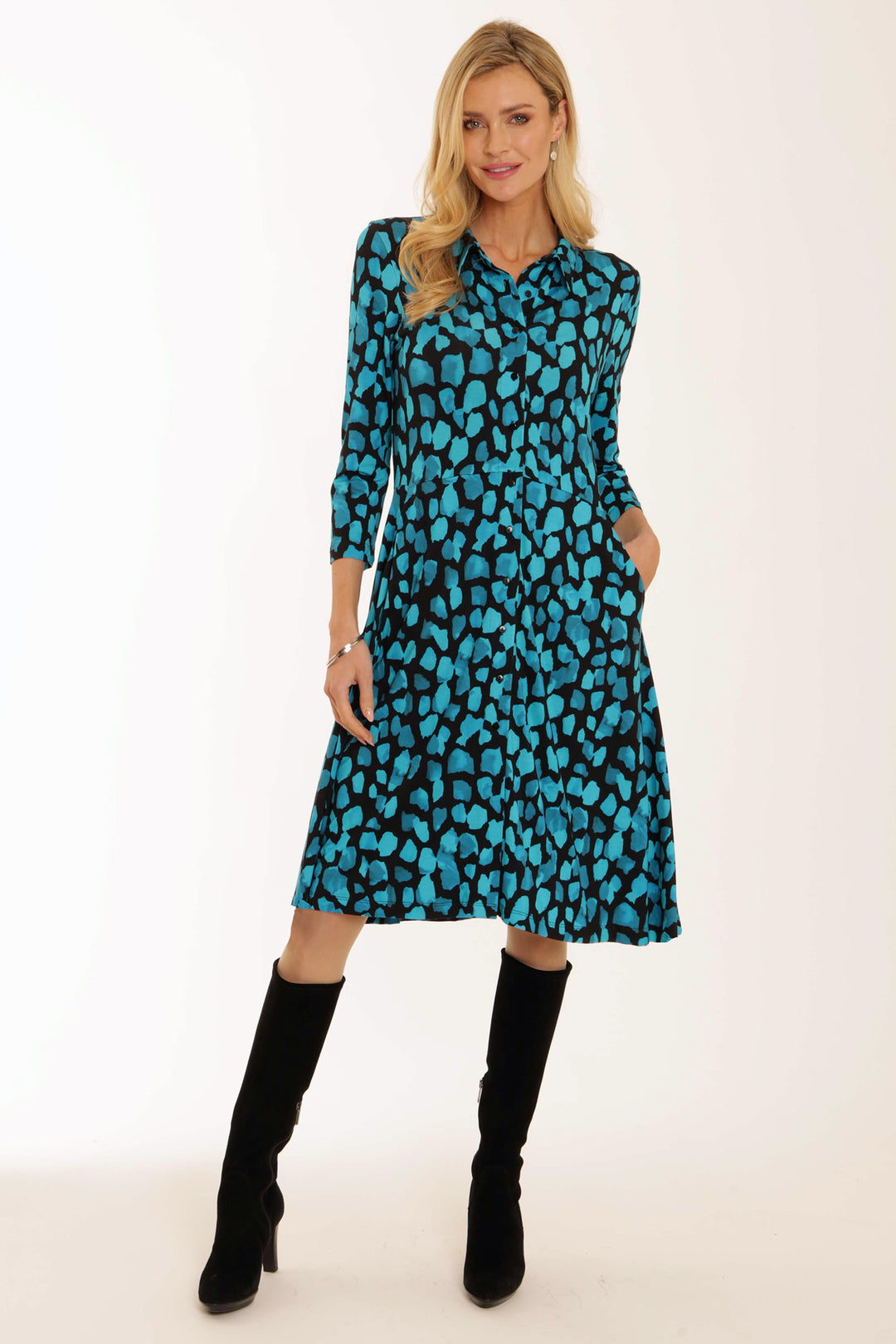 Woman wearing a blue patterned dress with long sleeves on a white background