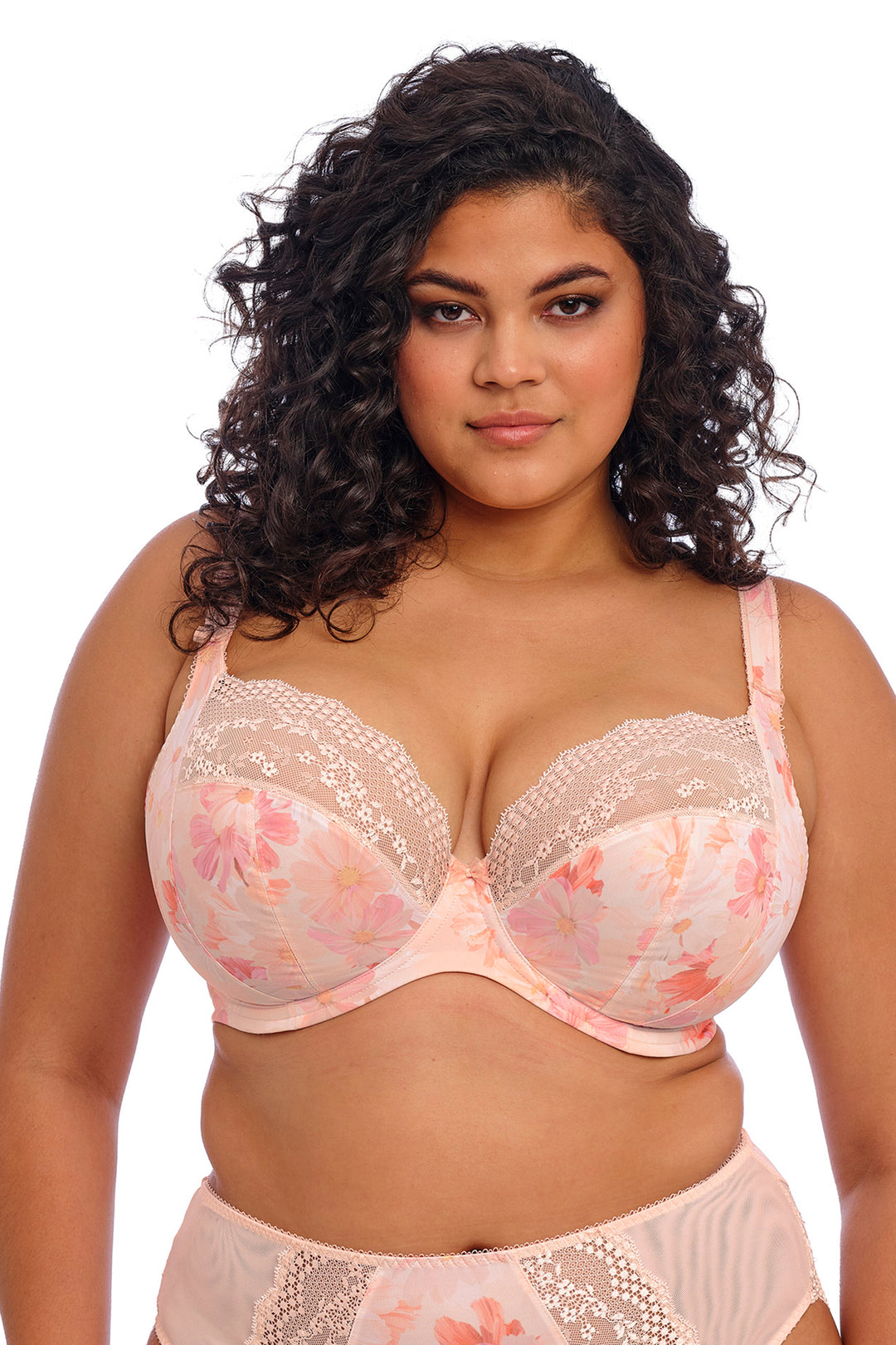 Woman wearing a pink lace bra and panties set on a white background