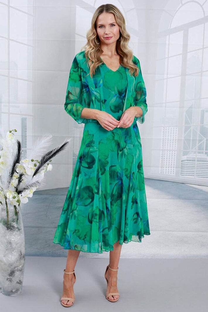 Woman wearing a green floral dress in a modern indoor setting