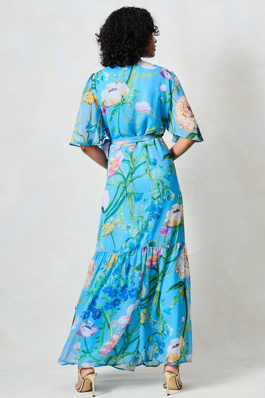 Woman wearing a blue floral dress against a white background