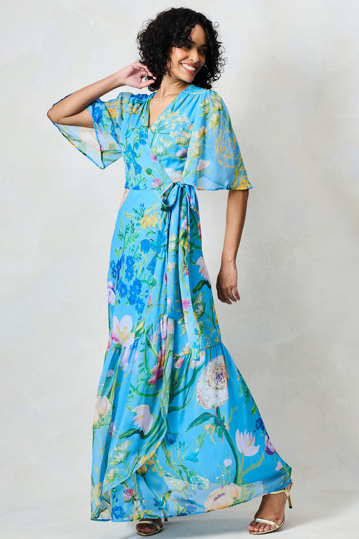 Woman wearing a blue floral dress against a white background