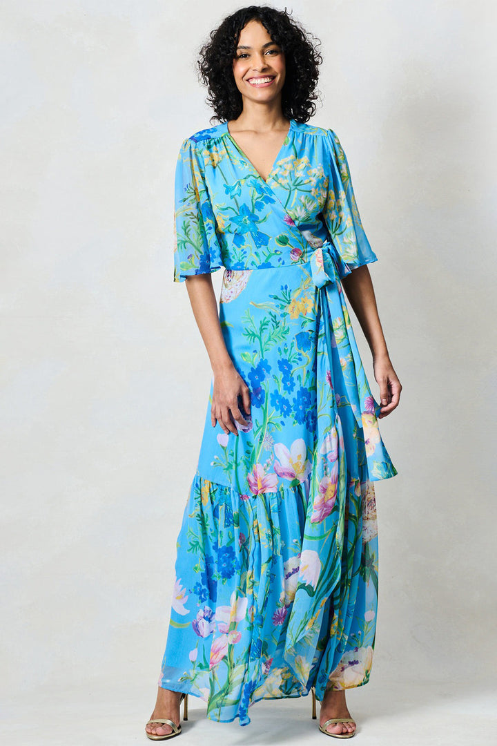 Woman wearing a blue floral dress against a white background
